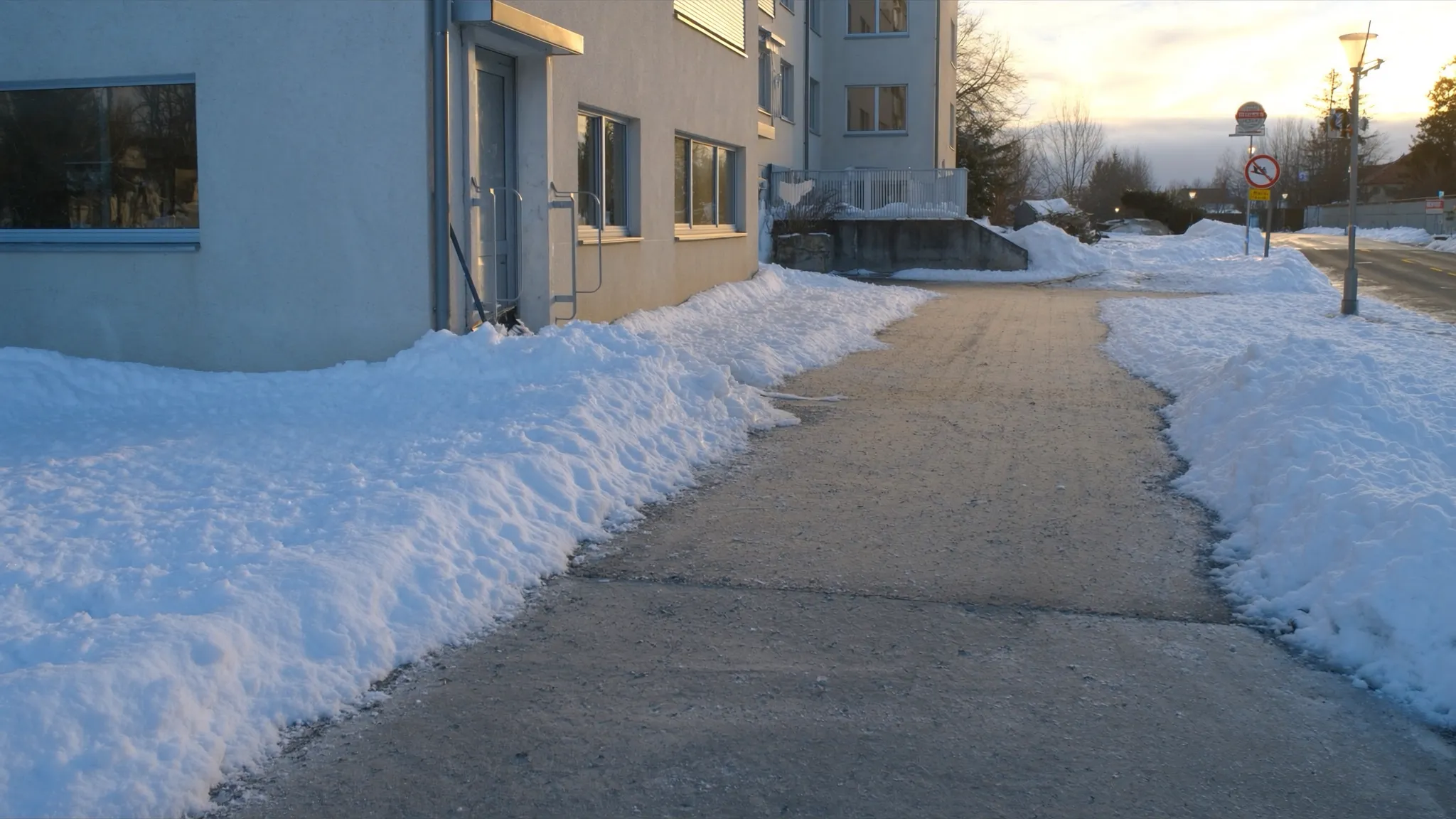 Geräumter Gehweg vor einem Gebäude im Winter